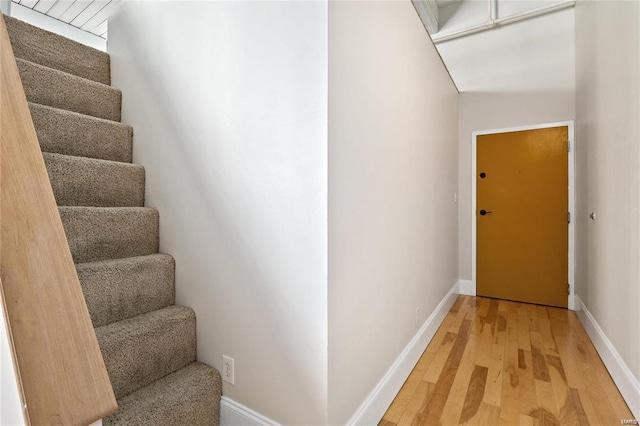 stairs with wood finished floors and baseboards