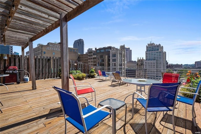 wooden terrace featuring area for grilling, a view of city, and a pergola