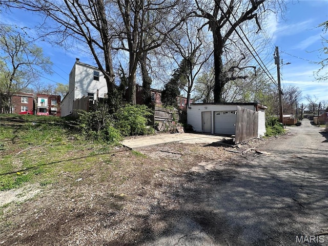 2108 Chippewa St, Saint Louis, MO 63118 - view of yard featuring dirt driveway, an outbuilding, and a detached garage