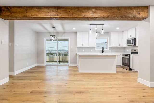 1121 E Cap Au Gris St, Troy, MO 63379 - kitchen with appliances with stainless steel finishes, beamed ceiling, a sink, white cabinetry, and tasteful backsplash