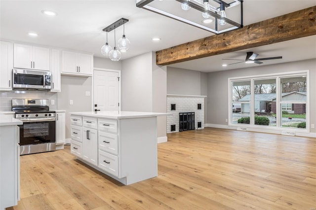 1121 E Cap Au Gris St, Troy, MO 63379 - kitchen with stainless steel appliances, open floor plan, light countertops, white cabinets, and beam ceiling