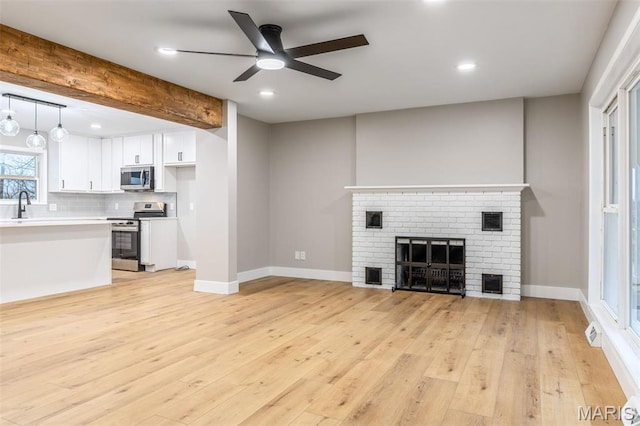 1121 E Cap Au Gris St, Troy, MO 63379 - unfurnished living room featuring ceiling fan, a sink, light wood-style floors, baseboards, and recessed lighting