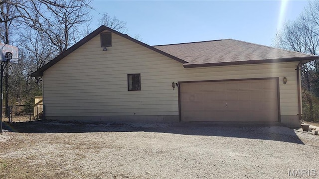1020 White Hawk Dr, Cuba, MO 65453 - view of property exterior with roof with shingles, dirt driveway, and an attached garage
