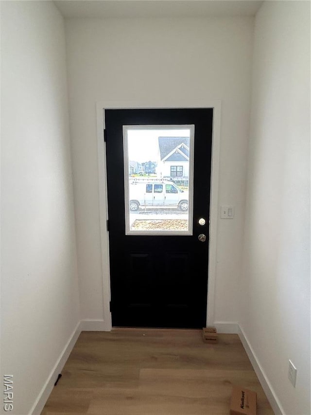 doorway featuring light wood-type flooring and baseboards