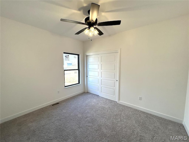 unfurnished bedroom with carpet, baseboards, a closet, and ceiling fan