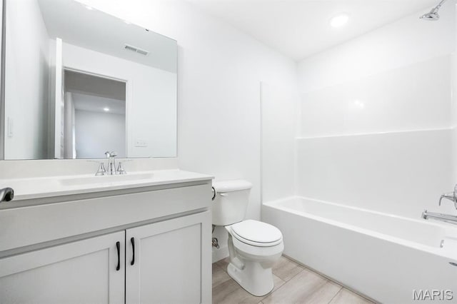 full bathroom featuring toilet, vanity, wood finished floors, and bathtub / shower combination