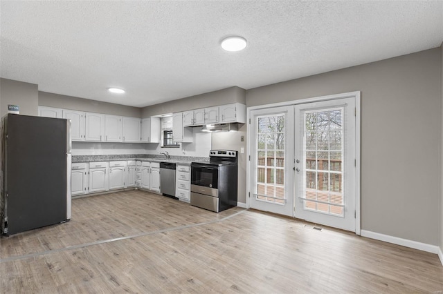 1680 Neff Rd, Saint Clair, MO 63077 - kitchen featuring appliances with stainless steel finishes, french doors, white cabinetry, light wood-style floors, and a textured ceiling