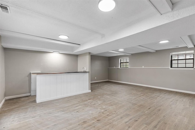 1680 Neff Rd, Saint Clair, MO 63077 - below grade area with wood finished floors, a textured ceiling, baseboards, and bar area