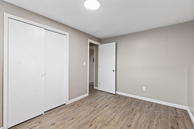1680 Neff Rd, Saint Clair, MO 63077 - unfurnished bedroom with light wood finished floors, a closet, baseboards, and a textured ceiling