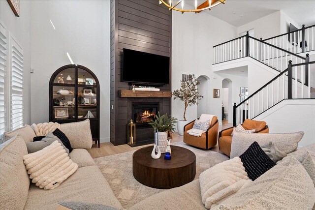 914 Memsie Park Ct, Ofallon, MO 63368 - living area with a towering ceiling, stairway, wood finished floors, arched walkways, and a fireplace