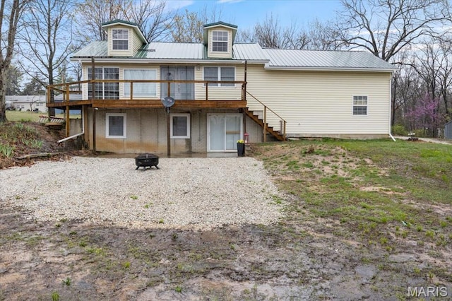 34441 Hickory Hills Rd, Mo, MO 65078 - back of property with an outdoor fire pit, a wooden deck, stairway, and metal roof