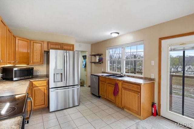 34441 Hickory Hills Rd, Mo, MO 65078 - kitchen with appliances with stainless steel finishes, a sink, light countertops, light tile patterned floors, and brown cabinets