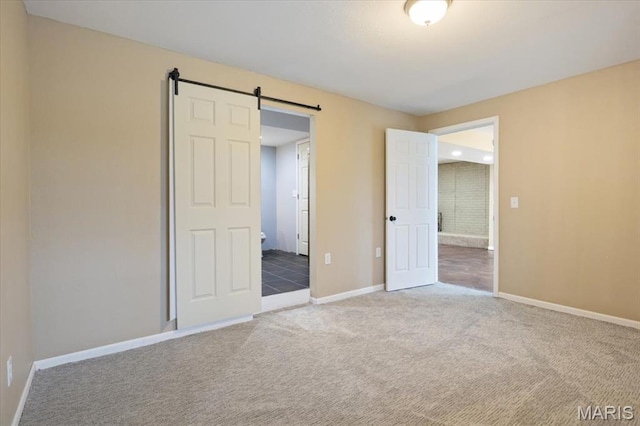 34441 Hickory Hills Rd, Mo, MO 65078 - unfurnished bedroom featuring baseboards, a barn door, and carpet floors