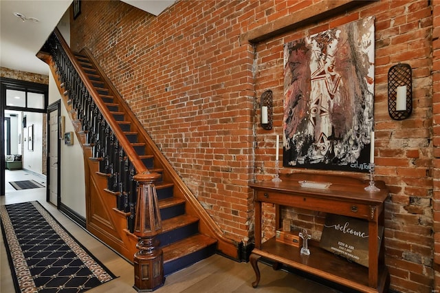 910 Lami St, Saint Louis, MO 63104 - stairway featuring wood finished floors, brick wall, and baseboards