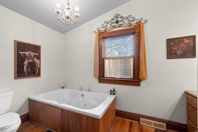 312 Bellevue St, Cape Girardeau, MO 63701 - full bathroom featuring toilet, baseboards, wood finished floors, a tub with jets, and a chandelier