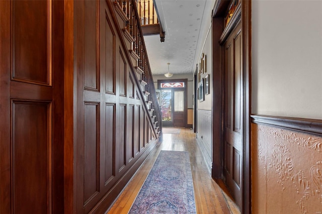 312 Bellevue St, Cape Girardeau, MO 63701 - corridor featuring light wood-style floors, stairway, a wainscoted wall, and a decorative wall