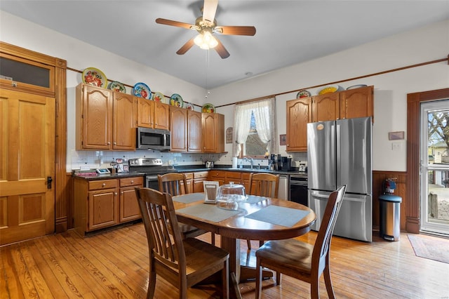 312 Bellevue St, Cape Girardeau, MO 63701 - kitchen with stainless steel appliances, dark countertops, a wainscoted wall, light wood finished floors, and ceiling fan