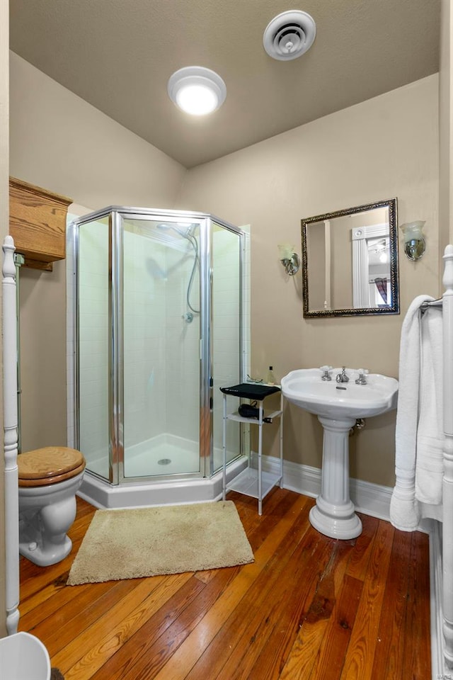 312 Bellevue St, Cape Girardeau, MO 63701 - full bathroom featuring wood finished floors, a stall shower, toilet, and baseboards
