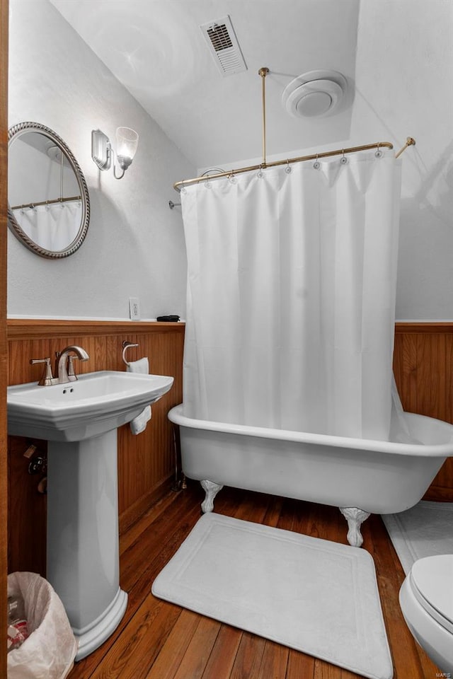 312 Bellevue St, Cape Girardeau, MO 63701 - full bathroom with wood finished floors, a wainscoted wall, a bath, a shower with curtain, and wooden walls