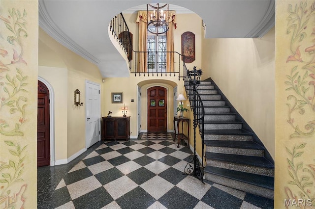 8 Carrswold Dr, Clayton, MO 63105 - entrance foyer with a chandelier, arched walkways, stairway, a towering ceiling, and crown molding