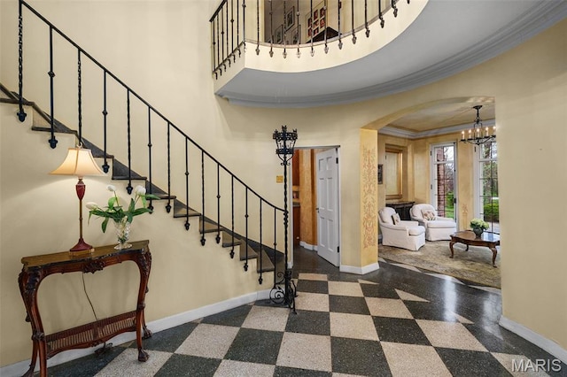 8 Carrswold Dr, Clayton, MO 63105 - foyer with baseboards, arched walkways, a chandelier, crown molding, and stairs