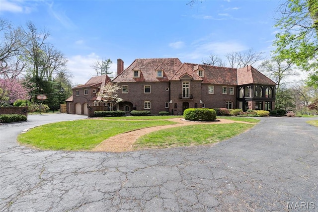 8 Carrswold Dr, Clayton, MO 63105 - english style home with a chimney, curved driveway, a front yard, and an attached garage