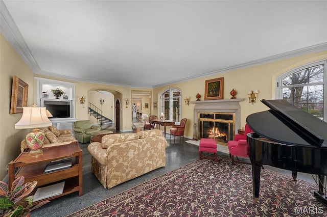 8 Carrswold Dr, Clayton, MO 63105 - living room featuring arched walkways, a glass covered fireplace, ornamental molding, baseboards, and stairway