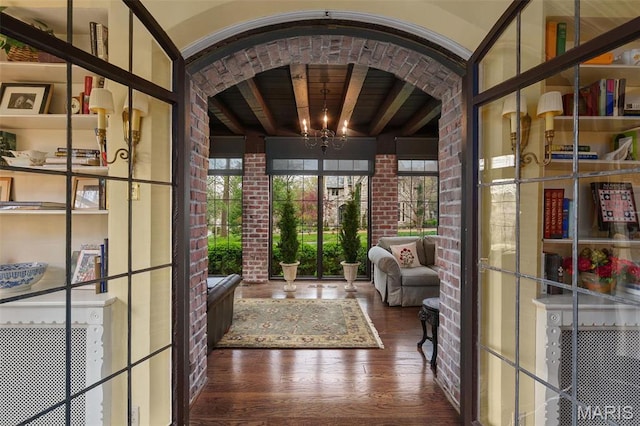 8 Carrswold Dr, Clayton, MO 63105 - doorway featuring wood finished floors, brick wall, a chandelier, beam ceiling, and wooden ceiling