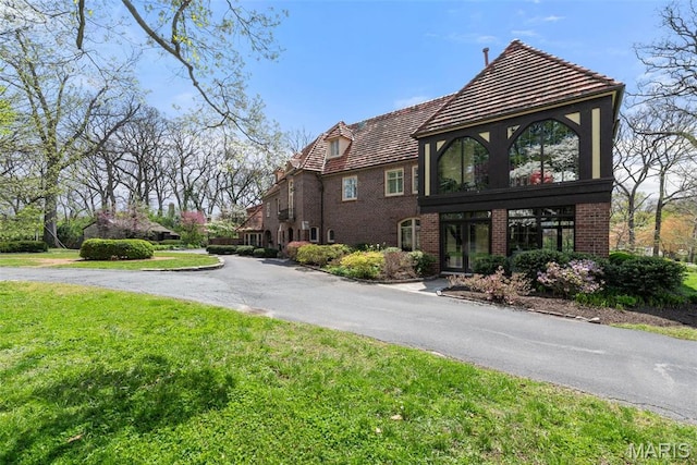 8 Carrswold Dr, Clayton, MO 63105 - view of property exterior with a yard, brick siding, and a tiled roof