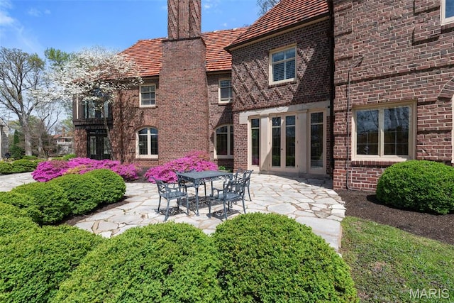 8 Carrswold Dr, Clayton, MO 63105 - rear view of house with a patio area, brick siding, and a chimney