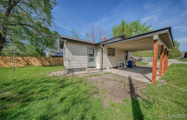 1003 S Warfel St, Salem, MO 65560 - back of property featuring a carport, a chimney, and a patio area
