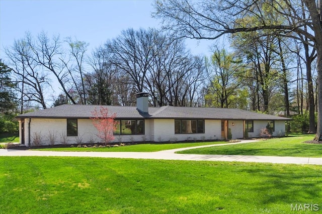 12 Westfield, Frontenac, MO 63131 - view of front of home featuring a front yard, a chimney, and brick siding