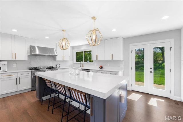 12 Westfield, Frontenac, MO 63131 - kitchen with exhaust hood, appliances with stainless steel finishes, recessed lighting, dark wood finished floors, and white cabinets