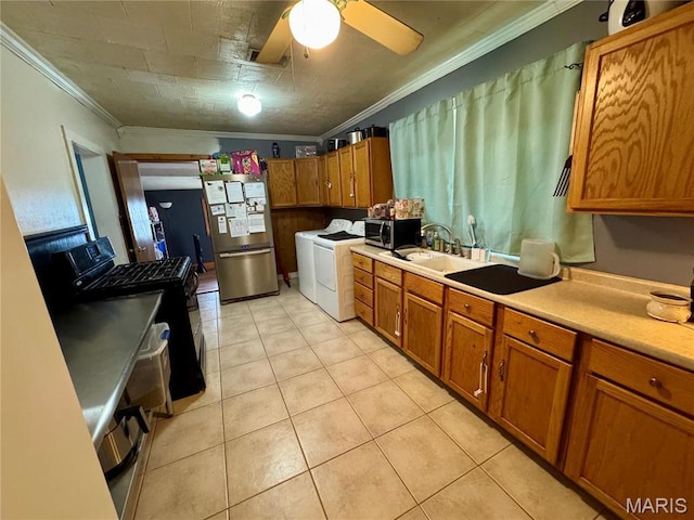 kitchen featuring stainless steel appliances, washing machine and clothes dryer, ornamental molding, brown cabinetry, and light countertops