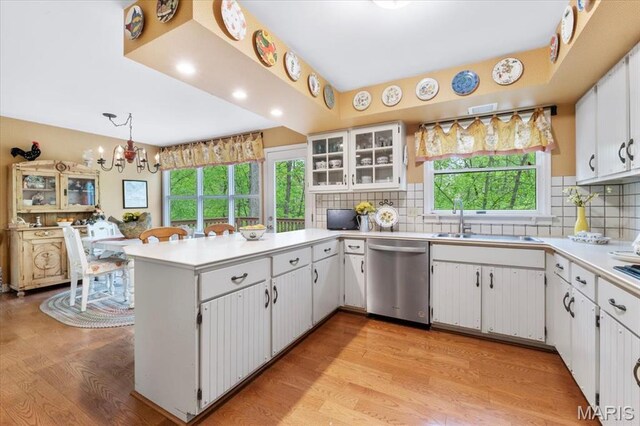 14590 Ansonborough Ct, Chesterfield, MO 63017 - kitchen featuring dishwasher, a sink, light wood-style floors, a peninsula, and a chandelier