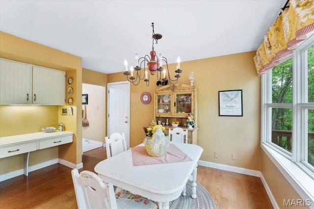 14590 Ansonborough Ct, Chesterfield, MO 63017 - dining room with wood finished floors, a chandelier, and baseboards