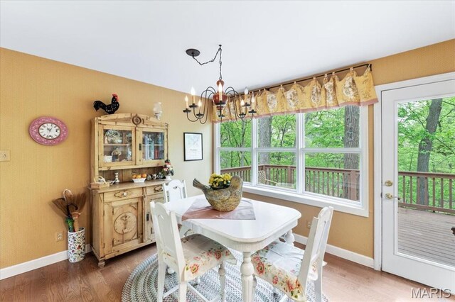 14590 Ansonborough Ct, Chesterfield, MO 63017 - dining space with a chandelier, baseboards, and wood finished floors