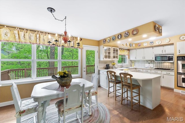 14590 Ansonborough Ct, Chesterfield, MO 63017 - kitchen featuring appliances with stainless steel finishes, a chandelier, tasteful backsplash, a sink, and white cabinetry