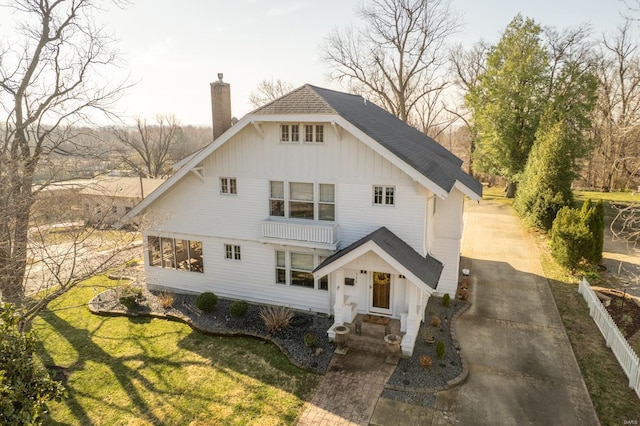 modern farmhouse style home featuring a chimney, a shingled roof, and a front yard