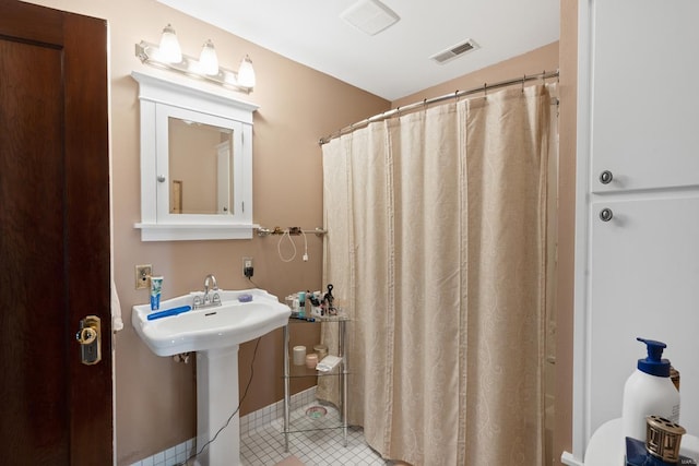 full bathroom featuring tile patterned flooring, a shower with curtain, and a sink