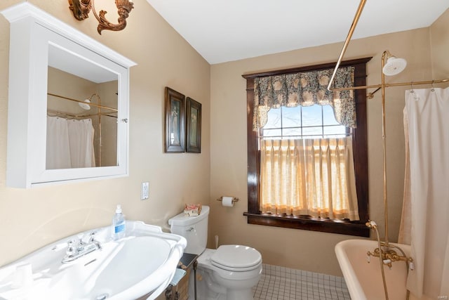 full bathroom with a sink, toilet, a freestanding bath, tile patterned flooring, and a shower with curtain