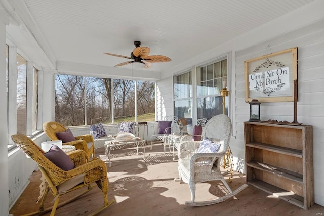 sunroom with a ceiling fan, healthy amount of natural light, and wood finished floors