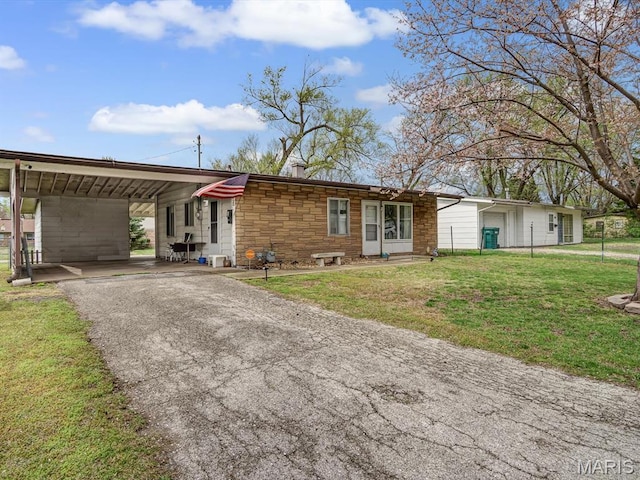 1120 Saint Michael Dr E, St Louis, IL 62206 - view of front of property with asphalt driveway, a front lawn, stone siding, and an attached carport