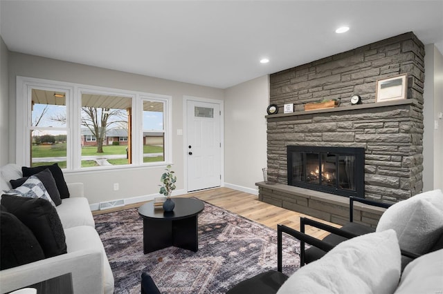 4 Tiger Dr, Wentzville, MO 63385 - living area with wood finished floors, baseboards, a stone fireplace, and recessed lighting