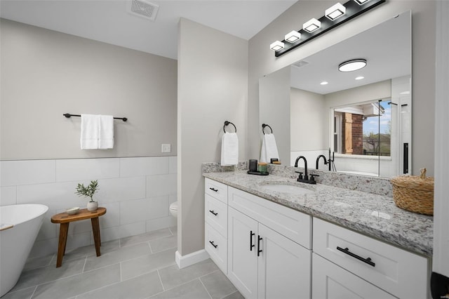 4 Tiger Dr, Wentzville, MO 63385 - full bath featuring tile walls, tile patterned floors, vanity, toilet, and a freestanding bath