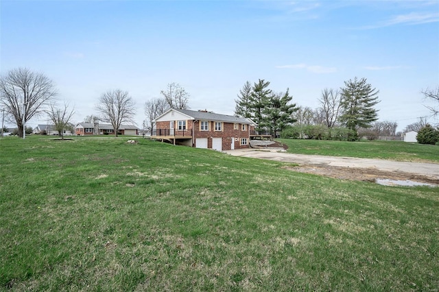 4 Tiger Dr, Wentzville, MO 63385 - view of grassy yard with driveway, a wooden deck, and an attached garage