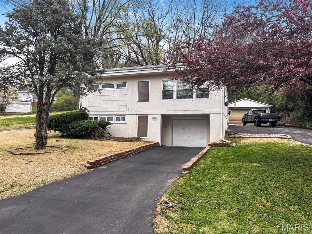 404 Hillside Dr, Collinsville, IL 62234 - view of front facade with asphalt driveway, an attached garage, a front yard, and stucco siding