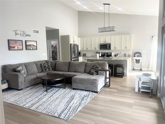 1564 Mandy Ln, Barnhart, MO 63012 - living room featuring high vaulted ceiling, light wood-style floors, and baseboards