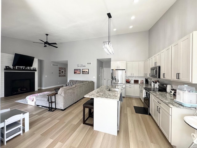 1564 Mandy Ln, Barnhart, MO 63012 - kitchen featuring stainless steel appliances, high vaulted ceiling, open floor plan, a ceiling fan, and white cabinetry