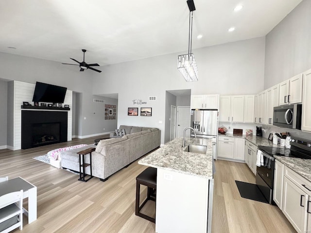 1564 Mandy Ln, Barnhart, MO 63012 - kitchen with stainless steel appliances, a high ceiling, a sink, ceiling fan, and light stone countertops